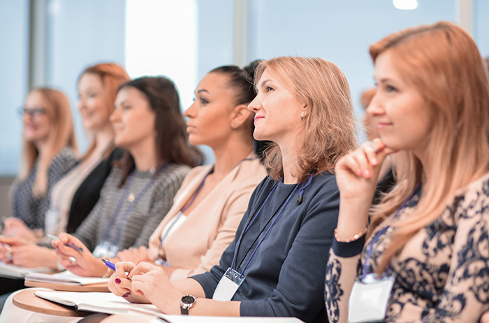 Mitarbeiteraufklärung, Vorträge und Sammelbestellung Eine Konferenz, bei der sechs Frauen interessiert und aufmerksam nach vorne schauen und sich einen Vortrag zu Gebärmutterhalskrebs und zum S-Pap anhören.