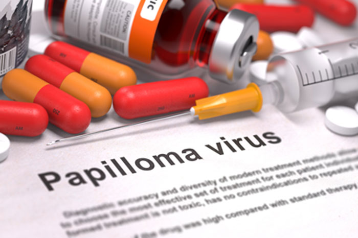 Die HPV-Impfung bietet keinen zuverlässigen Schutz. Prüfen Sie mit einer sicheren Abstrich-Diagnostik, ob trotz Impfung Zellveränderungen entstanden sind. Spritze mit schlanker Kanüle, Glasflasche mit Impfstoff, rot-orange Kapseln und weiße Tabletten auf einem Papier mit der Aufschrift "Papilloma virus".